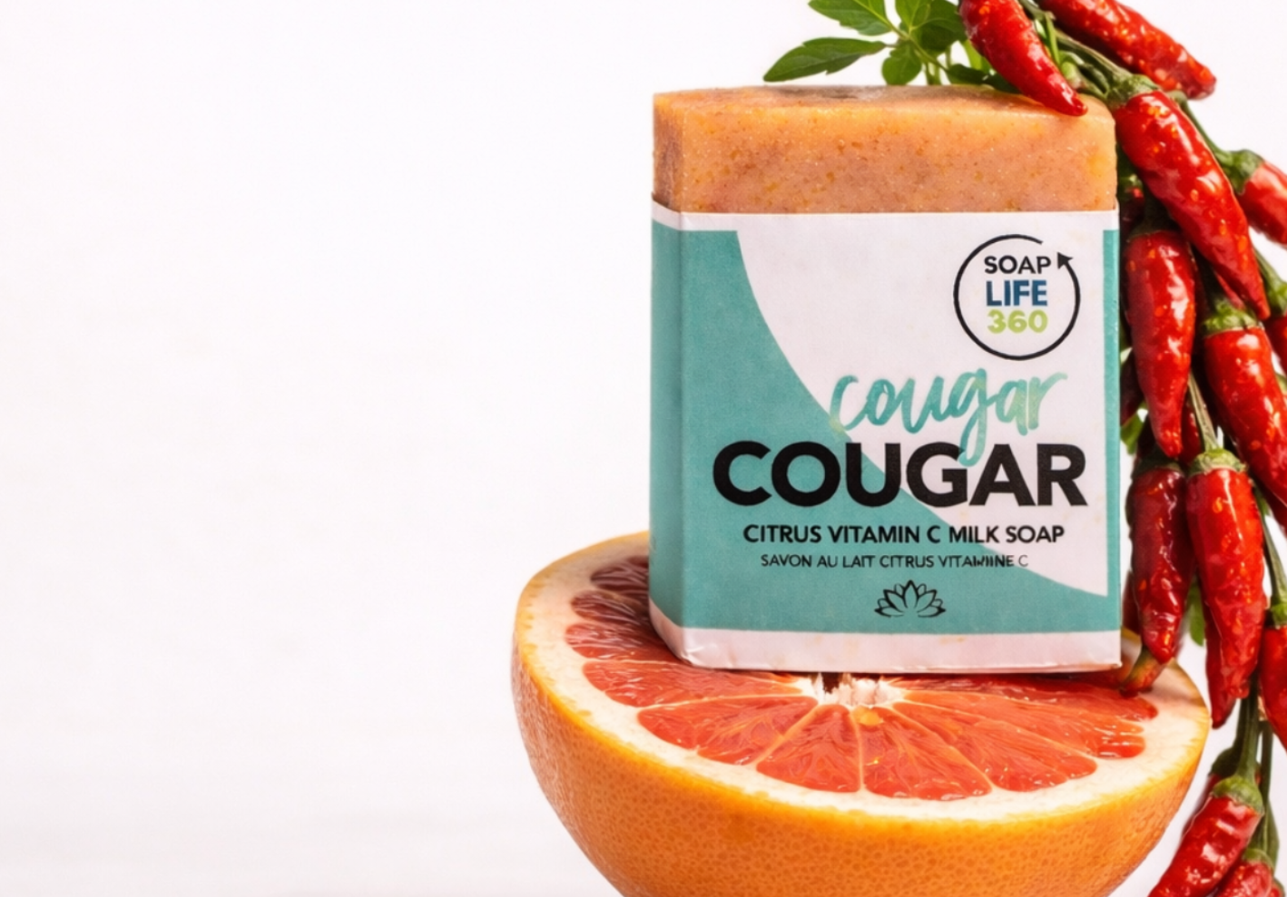 Bar of soap labeled 'Cougar' with a half-grapefruit and red chili peppers on a white background