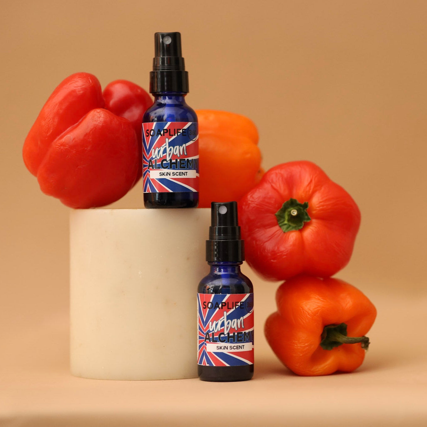 Two bottles of 'Vegan' product on a beige surface with red and orange peppers.