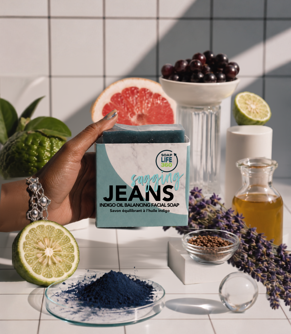 Hand holding a soap bar labeled 'Fragrant Jeans' with a natural setting including fruits and plants.