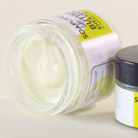 Jar of Butter Shea Cream with a black lid on a light background