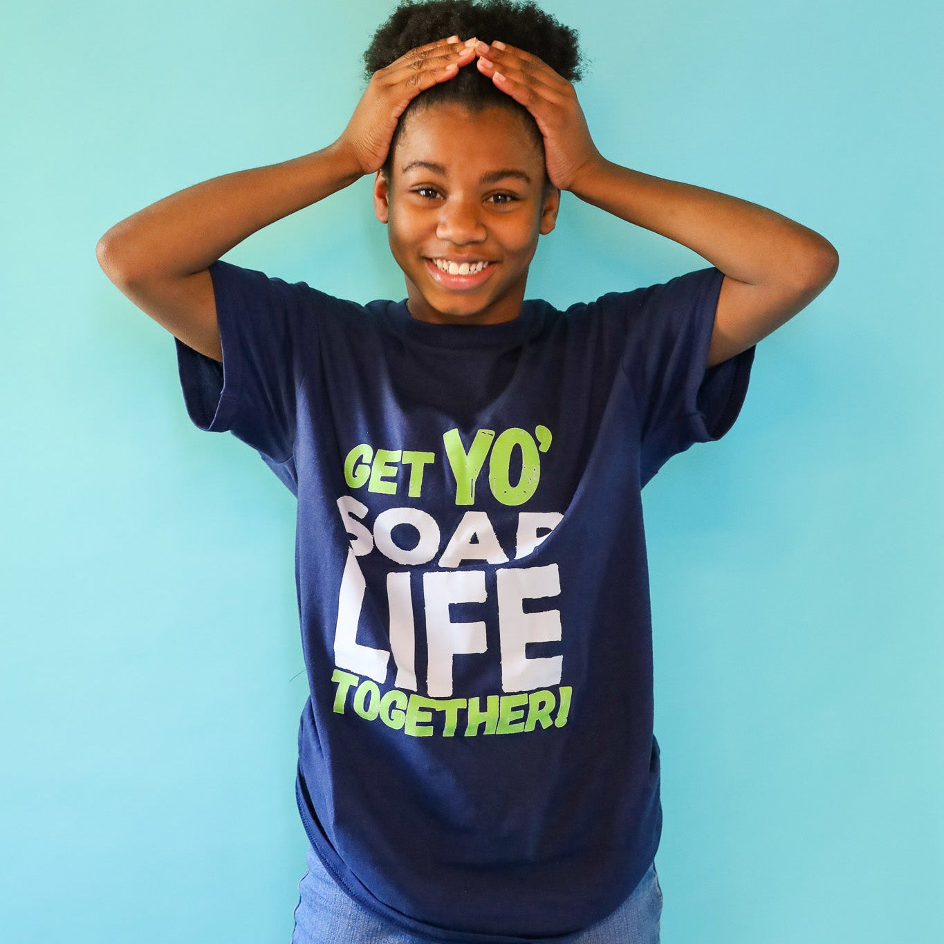 queen wearing a navy blue t-shirt with colorful text against a light blue background
