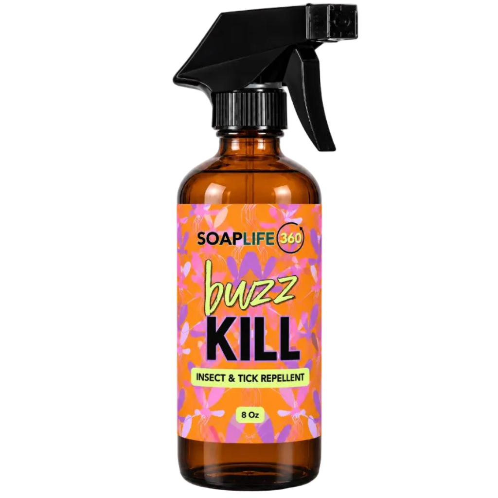 An 8 oz amber glass spray bottle of SoapLife360 'Buzz Kill' insect and tick repellent, featuring a black trigger spray top and a vibrant orange and pink floral label.